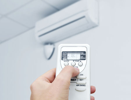 An image showing a white remote control operating a Commercial Air Conditioning system.